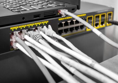 Laptop en router met groot aantal aangesloten netwerkkabels